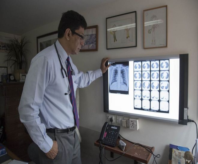 Доктор Зарир Удвадия смотрит на рентгеновские снимки