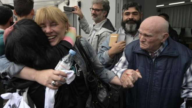 Карлос Гарейс (справа), бывший работник Ford и политзаключенный, держит руку своей дочери Эстелы (в центре) после решения суда в Буэнос-Айресе, Аргентина. Фото: 11 декабря 2018 года