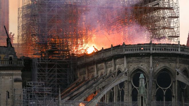 Пламя и дым вздымаются с крыши собора Нотр-Дам в Париже