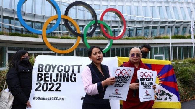 People protest next to 'boycott Beijing 2022' signs