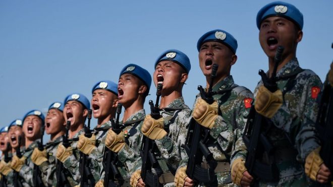 A row of Chinese soldiers shouting during marching drills