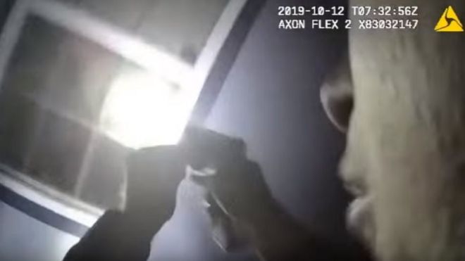 La cámara corporal de un agente registra el momento en que otro dispara por una ventana iluminada por una linterna