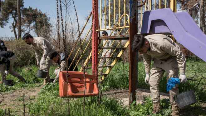 Explosives being cleared from a former playground in East Mosul