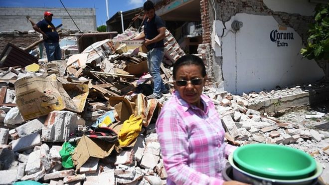 Una mujer retira pertenencias entre los escombros en Oaxaca, México, tras el terremoto del jueves.