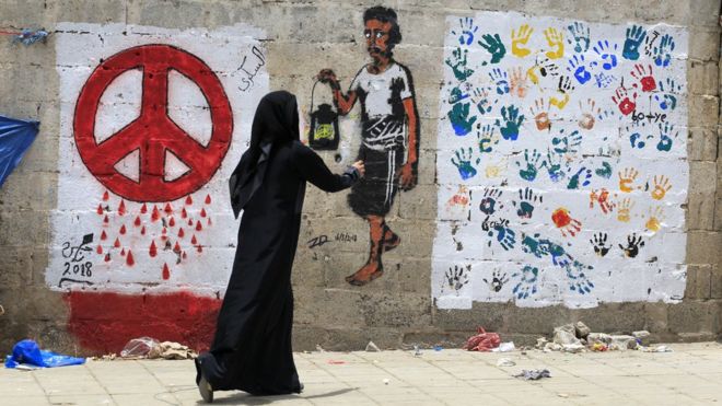 Йеменский художник рисует граффити за мир на стене в Сане, Йемен (16 августа 2018 года)