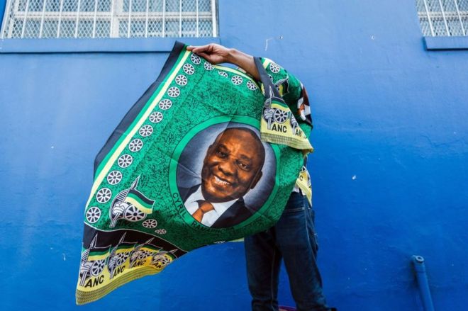 Уличный торговец продает товары с изображением президента Южной Африки Сирила Рамафосы 12 января 2019 года.
