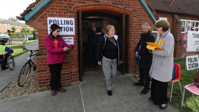 Избиратель покидает здание муниципалитета Трампингтон в Кембриджшире