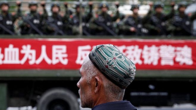 Uighur looks at military police in Xinjiang
