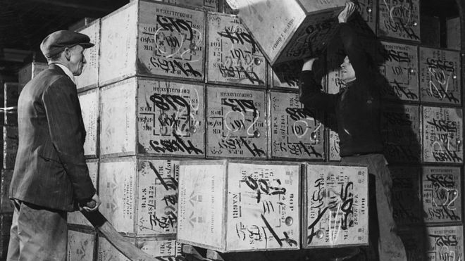 Владельцы портового управления Лондона грузят чайные сундуки в курган. 1950-е годы