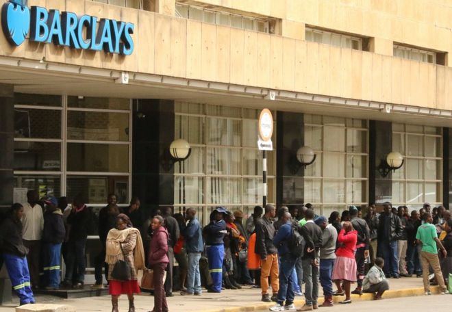 Люди стоят в очереди, чтобы снять наличные в отделении банка Barclays в Хараре, Зимбабве
