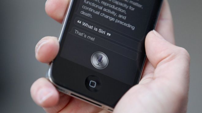 Человек использует Siri на iPhone 4S 14 октября 2011 года в Лондоне, Англия
