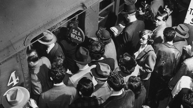Los pasajeros de la hora pico que abordan el tren subterráneo de Sea Beach desde una plataforma abarrotada en Times Square en la ciudad de Nueva York