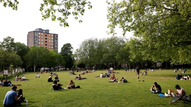 Люди сидят в парке в Лондоне