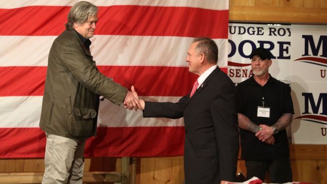 Кандидат в сенаторы от Республиканской партии Рой Мур приветствуется на сцене Стивом Бэнноном (слева), когда он представляет его во время предвыборной кампании на Oak Hollow Farm 5 декабря 2017 года в Фэрхопе, штат Алабама.