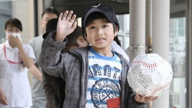 Yamato Tanooka, who was found after being abandoned by his parents as punishment in a forest, waves as he leaves a hospital in Hakodate on the northern island of Hokkaido Tuesday, June 7, 2016.