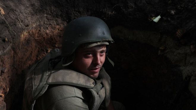A Ukrainian soldier sits in a foxhole at a position along the front line in the Donetsk region on 15 August 2022