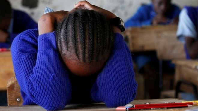 A pupil prays inside a classroom ahead of the primary school final national examinations at a school on Juja road in Nairobi.
