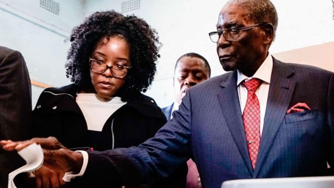 Бона Мугабе (слева) помогает своему отцу Роберту Мугабе голосовать в Зимбабве - понедельник, 30 июля 2018 года
