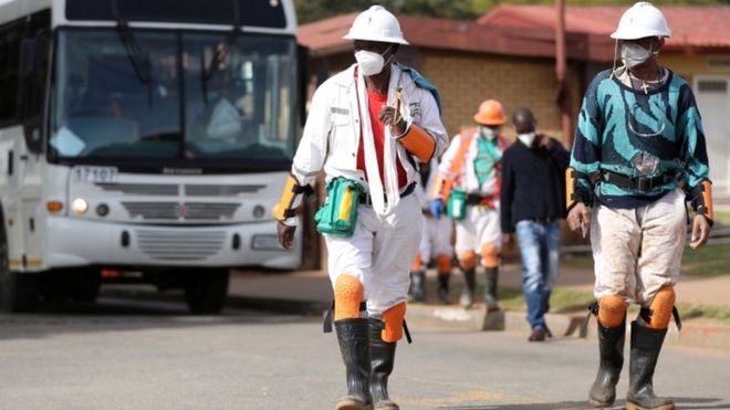 Mine workers wearing face masks arrive at a mine in Carletonville, South Africa, 19 May 2020