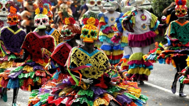 Люди в красочных костюмах и масках черепа на параде