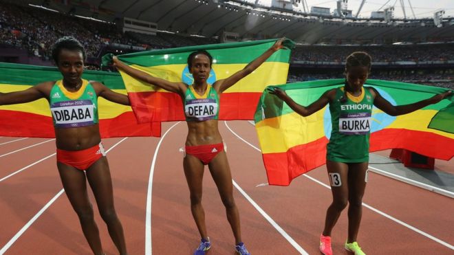 Эфиопские спортсмены празднуют после завоевания золота в финальном забеге на 5000 метров среди женщин на Олимпийских играх 2012 года в Лондоне