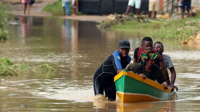 A man ferries residents through a flooded road in the aftermath of Cyclone Kenneth in Pemba, Mozambique, April 29, 2019.