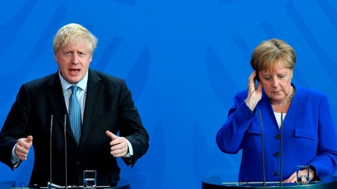 British Prime Minister Boris Johnson and German Chancellor Angela Merkel (R) speak to journalists at the Chancellery