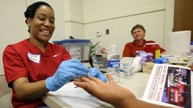 A UCLA nurse checks the gluclose level of a man during a health screening