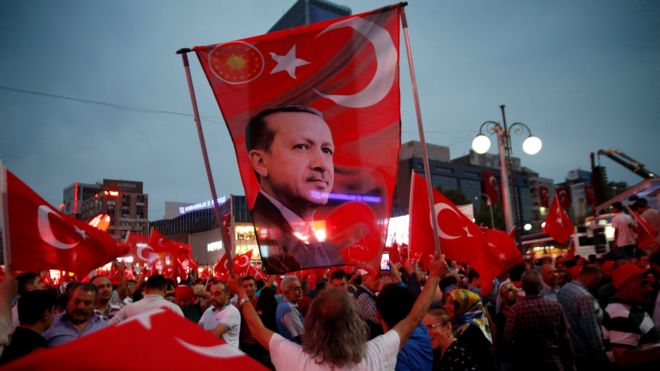 A supporter holds a flag depicting Turkish President Tayyip Erdogan during a pro-government demonstration in Ankara, Turkey, July 20, 2016.