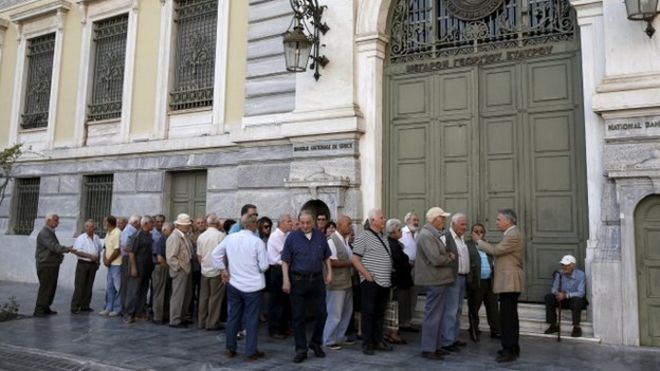 Пенсионеры стоят возле Национального банка в Афинах