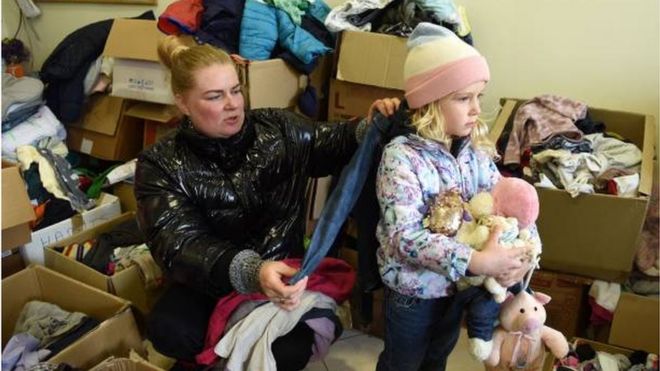 طفلة مع والدتها في مركز توزيع للاعانات في مدينة ليفيف