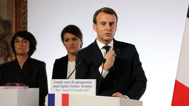 French President Emmanuel Macron (R) stands next to French Junior Minister for Gender Equality Marlene Schiappa (C) and French humorist and patron of association Women Safe Florence Foresti as he delivers a speech during the International Day for the Elimination of Violence Against Women, on 25 November 2017 at the Elysee Palace in Paris