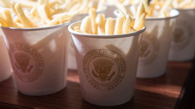 Эта фотография показывает картофель фри, помещенный в президентские чашки
