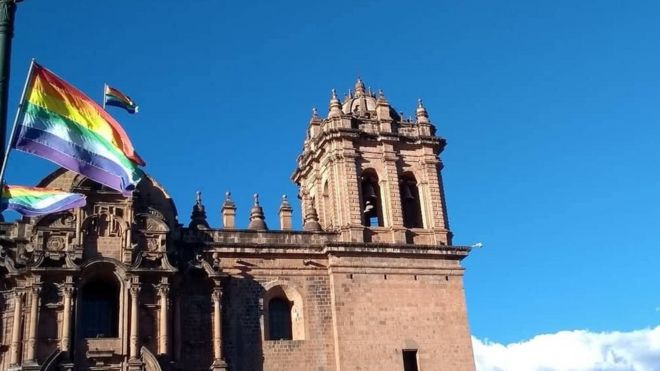 Vista de prédio histórico em Cusco com bandeiras de arco-íris que representam a cidade