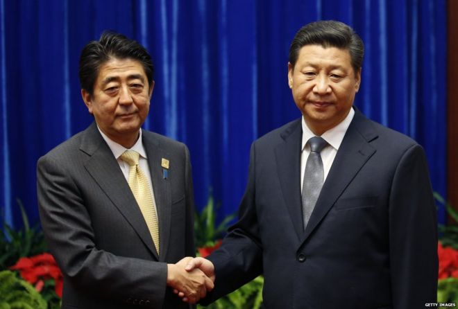 Президент Китая Си Цзиньпин (справа) обменивается рукопожатиями с премьер-министром Японии Синдзо Абэ во время их встречи в Большом зале народа в кулуарах встреч Азиатско-Тихоокеанского экономического сотрудничества (АТЭС) 10 ноября 2014 года в Пекине, Китай.