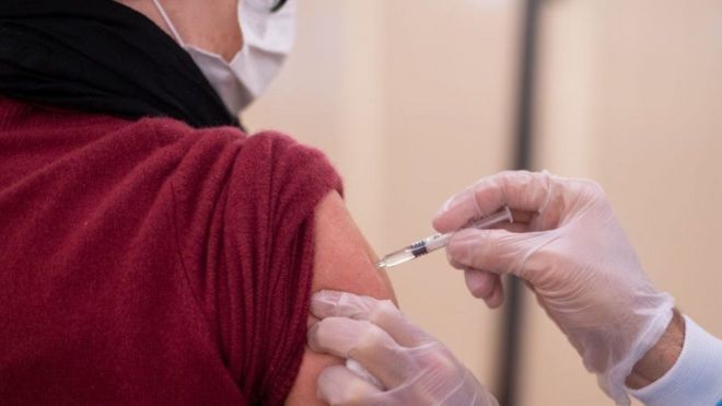 Una persona recibiendo una vacuna en un brazo.