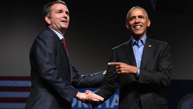 Бывший президент США Барак Обама (R) указывает на кандидата в губернаторы Демократической партии Ральфа Нортама
