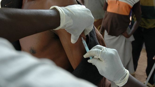 Profissional de saúde aplica injeção em braço de paciente