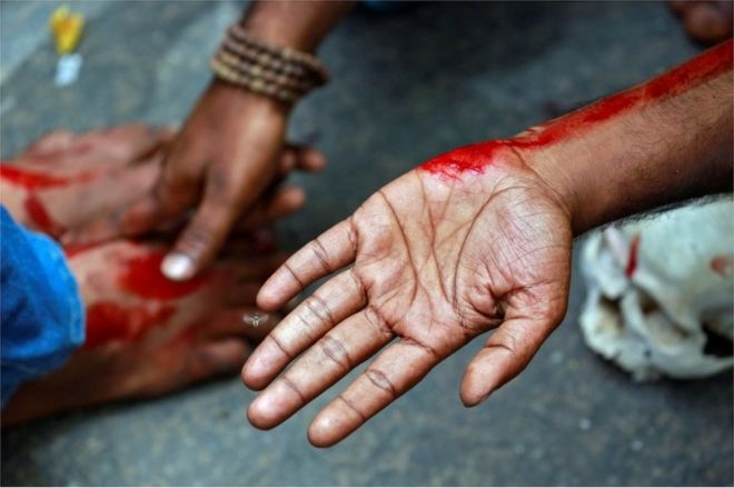 Фермер из южного штата Тамилнад протирает кровь на ногах своих коллег-протестующих после того, как намеренно порезался лезвием бритвы во время акции протеста, требующей пакета помощи от засухи от федерального правительства, в Нью-Дели, Индия, 7 апреля 2017 года. || | Тамил Наду был охвачен засухой более двух лет