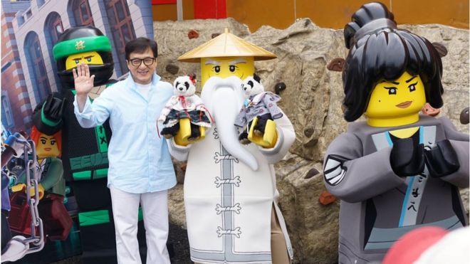 Джеки Чан позирует с фигурами Ниндзяго Лего