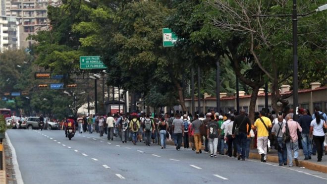 Люди ходят по улицам Каракаса во время отключения электричества