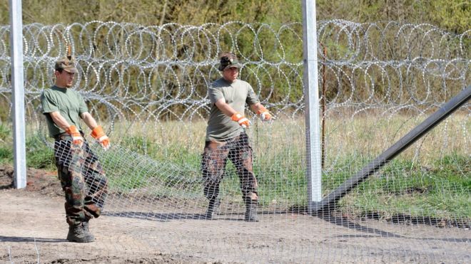 Венгерские солдаты выкатывают колючую проволоку