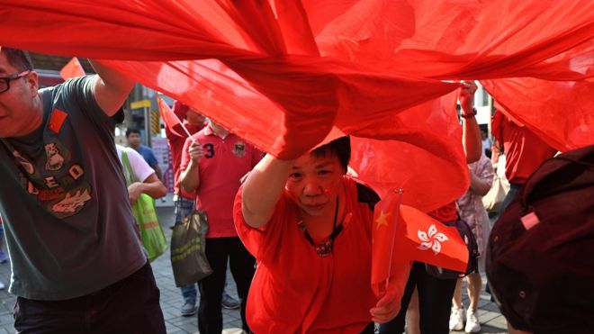 Một phụ nữ cầm cờ Hong Kong giữa cuộc biểu tình của người thân Bắc Kinh ở Hong Kong hôm 1/10, ngày kỷ niệm 70 năm cộng sản thống trị ở Trung Quốc