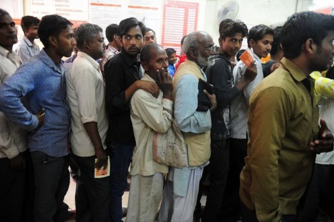 Индейцы стоят в очереди внутри банка, чтобы внести 500 и 1000 банкнот индийской рупии в деревне Рахимапур на окраине Аллахабада 10 ноября 2016 года.
