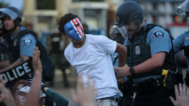 un manifestante es esposado por un agente blanco el 31 de mayo de 2020.