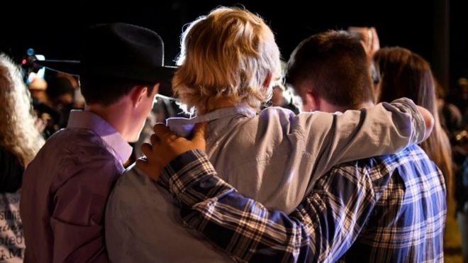 Местные жители обнимаются во время бдения при свечах для жертв массовых расстрелов в церкви в Сазерлендской весне (06 ноября 2017 г.)