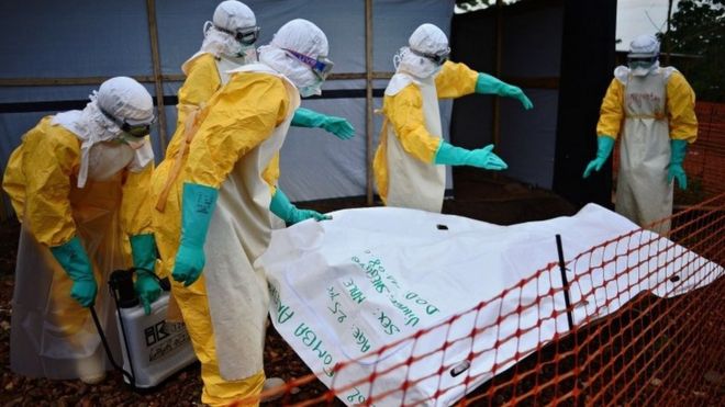 Медицинские работники Medecins Sans Frontieres (MSF) проводят дезинфекцию мешка с телом жертвы Эболы в учреждении Medecins Sans Frontieres (MSF) в Кайлахуне 14 августа 2014 года