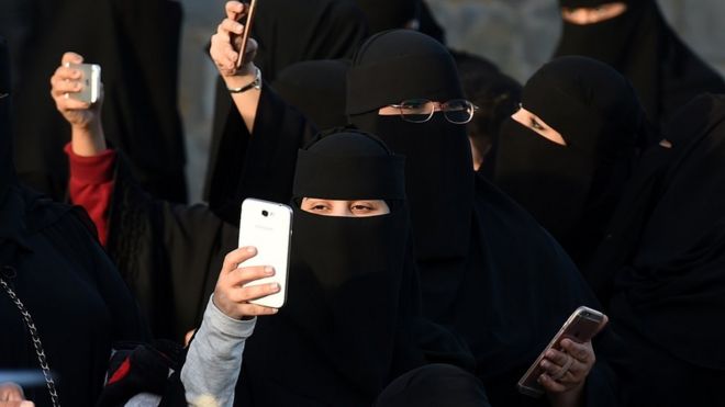 Saudi women use their mobile phones during the Janadriyah festival of Heritage and Culture held in the Saudi village of Al-Thamama, 50 kilometres north of the capital Riyadh