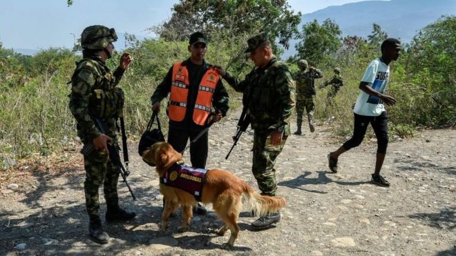 Колумбийские солдаты сопровождают члена Боливарианских национальных вооруженных сил Венесуэлы, который дезертировал в Колумбию со своей собакой в ??Кукуте 25 февраля 2019 года