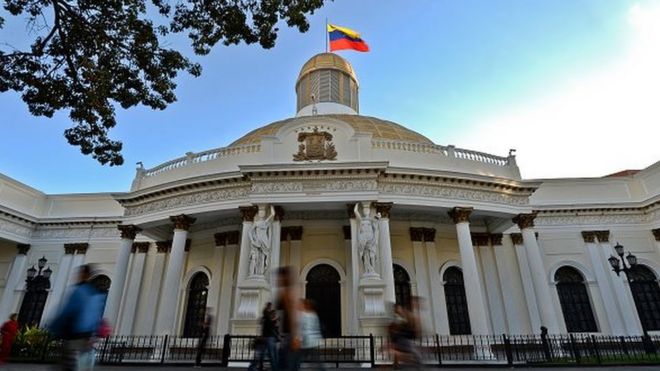 Люди проходят мимо здания Национального собрания в Каракасе 7 декабря 2015 года